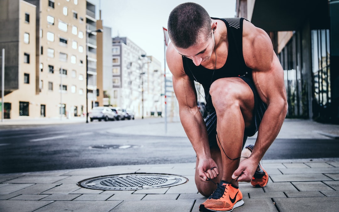 Physically fit man tying his shoes for mental fitness article
