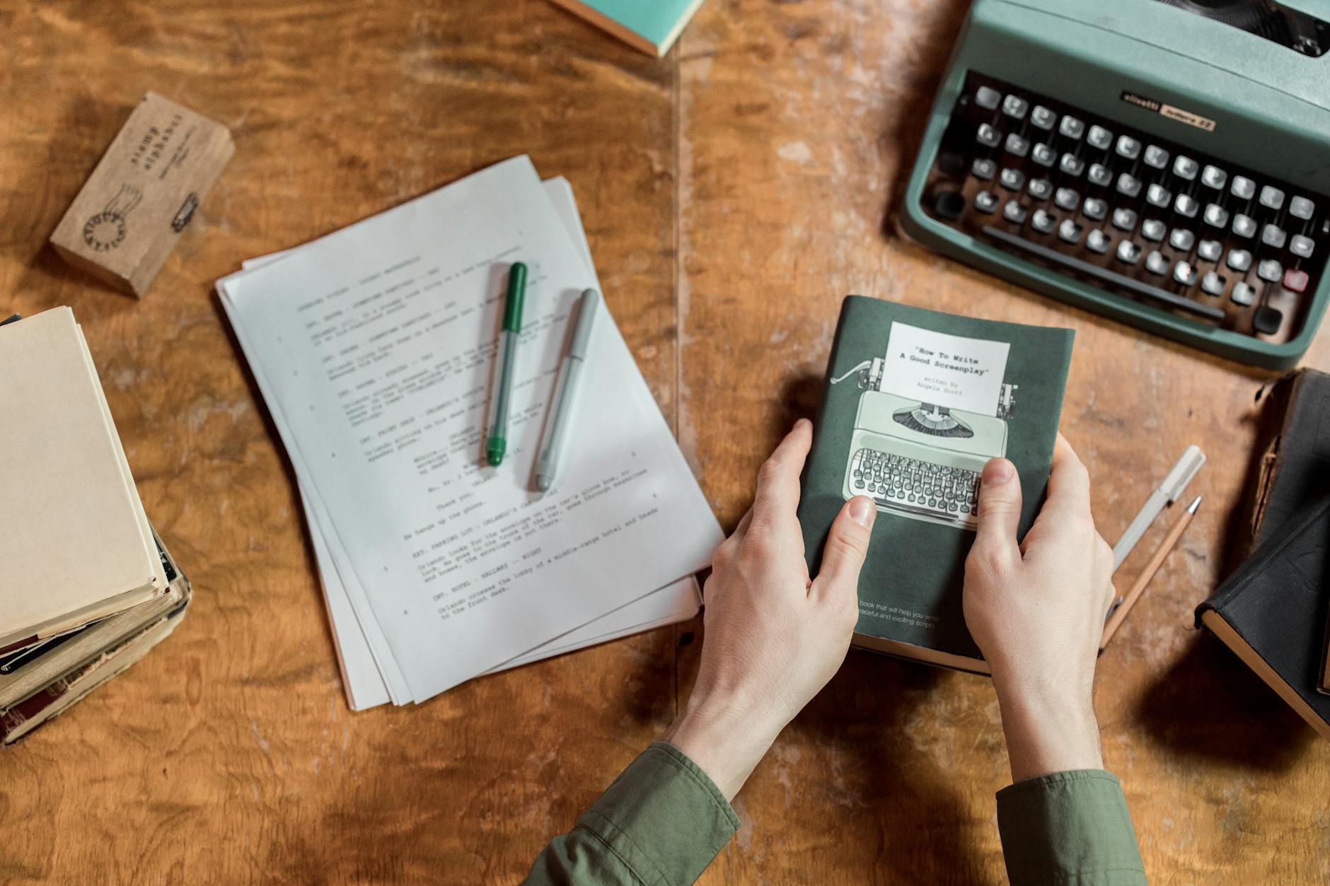 man sitting at desk with paperwork and typewriter