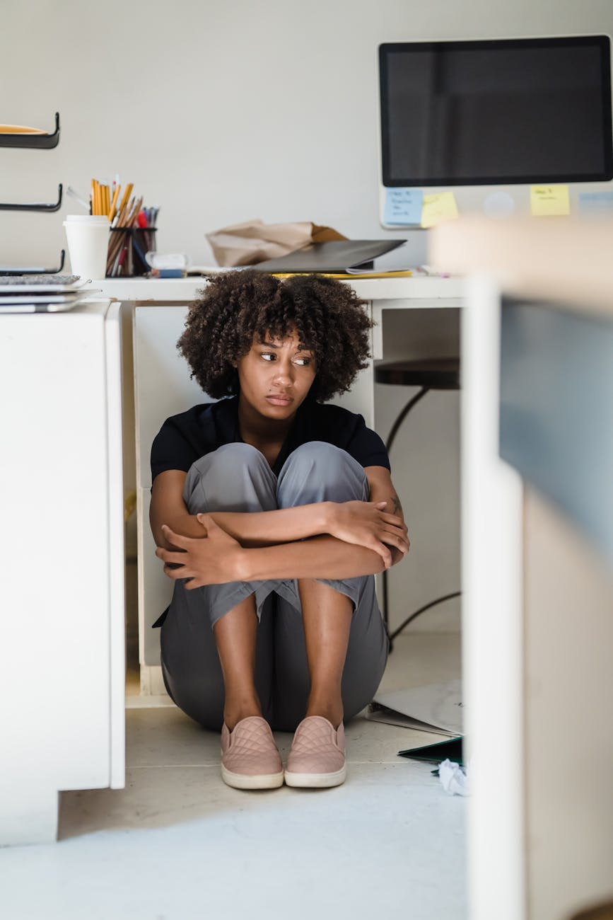 woman hiding under her desk